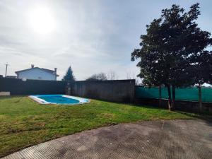 a backyard with a swimming pool and a fence at Casa Sanmartín in Maside