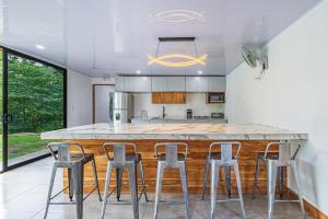 a kitchen with a large counter with stools around it at Bongo's Lodge in Arbolito