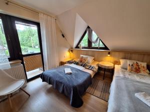 a bedroom with two beds and two windows at Pokoje Gościnne U Wandy in Zakopane