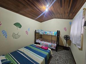 a bedroom with two bunk beds and a wooden ceiling at El Cacique Villeta Hostal in Villeta +67 photos