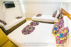 two beds in a room with ties on them at Hotel Portobahia Santa Marta Rodadero in Santa Marta