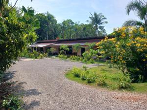 a house with a gravel driveway in front of a garden at Baan Long Beach in Ko Lanta