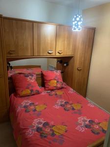 a bedroom with a bed with a red comforter at Appartement 5 personnes centre de Luchon in Luchon