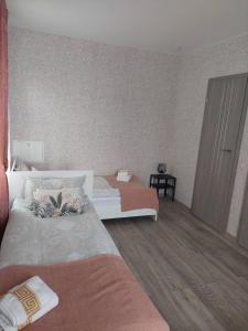 ein Hotelzimmer mit 2 Betten und einem Schrank in der Unterkunft Lapių Ola in Utena