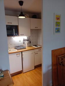 a small kitchen with white cabinets and a sink at Appartement 5 personnes centre de Luchon in Luchon +3 photos