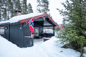 a cabin in the snow with two british flags at Villa Fregn in Ljørdal