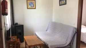 Habitación pequeña con cama, mesa y sidra de mesa en Casas Navarredonda, en Navarredonda