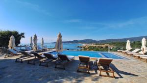 a swimming pool with lounge chairs and umbrellas at Sarti Thea in Sarti