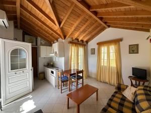 a kitchen and living room with a table and a couch at Eva's Apartments in Karlovasi