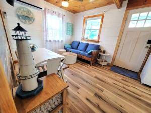 a living room with a blue couch and a lighthouse at Sea & Sun Cottage #1 in Hampton
