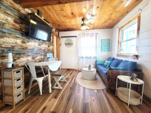 a living room with a blue couch and a table at Sea & Sun Cottage #1 in Hampton