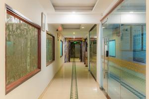 un couloir d'un bâtiment avec des peintures sur les murs dans l'établissement Fortune 1127 - Central Hotel, à Hô-Chi-Minh-Ville