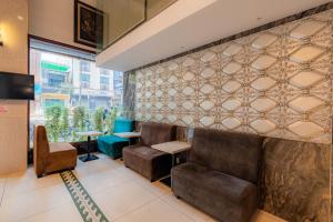 um restaurante com cadeiras de couro e uma parede com azulejos em Fortune 1127 - Central Hotel em Ho Chi Minh