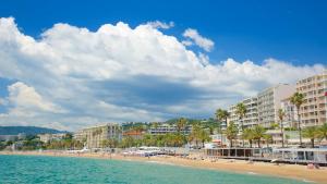 a beach with buildings and palm trees and the ocean at DELUXE SEAVIEW BALCONY - 2 min PALAIS & BEACH in Cannes