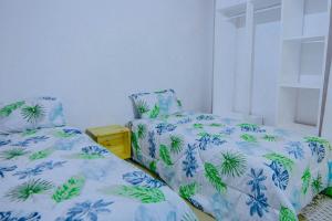 a bedroom with two beds with blue and green sheets at Winnie's Cozy Home in Iringa