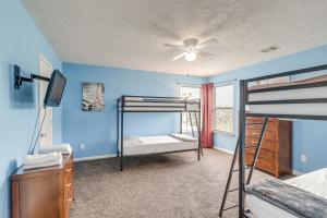a bedroom with two bunk beds and a ceiling fan at Houston Retreat with Pool Access and Fenced-In Yard! in Houston