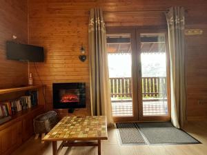TV a/nebo společenská místnost v ubytování Chalet entier, vue panoramique, ruisseau et sauna.