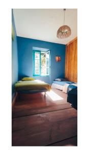 a bedroom with two beds and a blue wall at les Spartiates in Seix