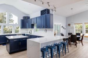 a kitchen with blue cabinets and a large island with bar stools at Casa Mariposa Newly Renovated Firepit*Fireplace*Great Deck*Pets Welcome! in Bee Cave