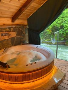 a large hot tub in a room with a wooden ceiling at Hoşdere Suit in Çamlıhemşin
