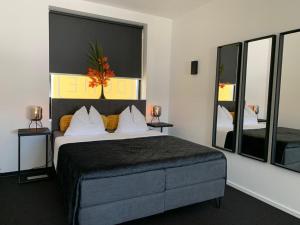 a bedroom with a large bed and two mirrors at Wellness Dome Penthouse in Kerkrade