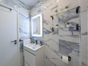 un bagno con lavandino e specchio di 2 Room Condo - 5 mins from Costa da Caparica Beach & Bars a Costa da Caparica Altre 58 foto