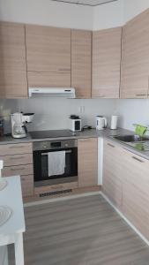eine Küche mit Holzschränken und einem Herd mit Backofen in der Unterkunft Meritähti 204 in Kalajoki