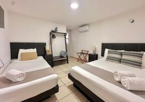 ein Schlafzimmer mit zwei Betten und einem Tisch in der Unterkunft Coco Suites by Andiani Travel in Cancún