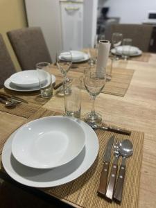 a wooden table with white plates and glasses on it at Encanto floral 2Pax - By Inside in Guaymallen +9 photos