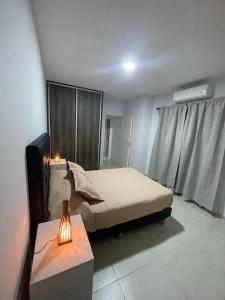 a bedroom with a bed and a table with a lamp at Encanto floral 2Pax - By Inside in Guaymallen