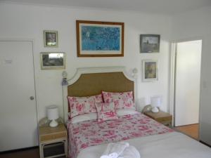 um quarto com uma cama com lençóis e almofadas cor-de-rosa em Glenellen Bed and Breakfast em Toowoomba