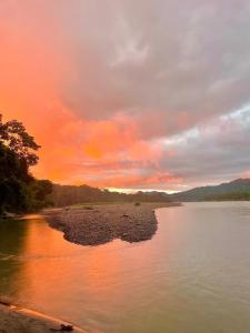 um pôr-do-sol sobre um rio com pedras na água em Shintuyahotsprings em Santa Rosa