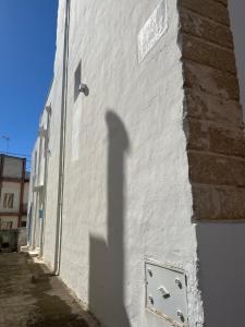 a shadow of a building on the side of a building at L’Edicola Votiva in Casarano +42 photos