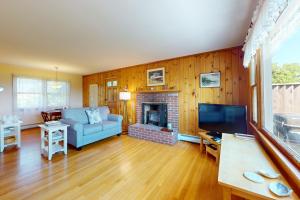 a living room with a blue couch and a fireplace at Lobster Tail Cottage in Castine