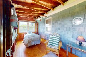 a bedroom with a bed and a chair in a room at Lobster Tail Cottage in Castine