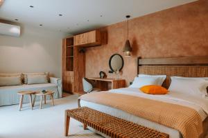 a bedroom with a large bed and a couch at Gabbana Beach Villas in Syvota