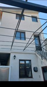 a white building with windows and a staircase on it at Kociu's House in Constanţa