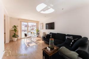 a living room with a black couch and a table at Colmar centre - L'Essentiel in Colmar