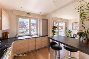 a kitchen with a table and two windows at Colmar centre - L'Essentiel in Colmar