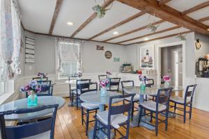 a dining room with blue tables and chairs at Olde Tavern Motel and Inn - Cape Cod in Orleans