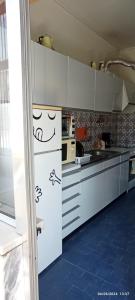 a kitchen with white cabinets with drawings on it at Apartamento Varanda do Sol in Amora
