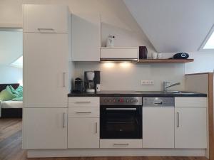 a kitchen with white cabinets and a stove at Seeappartements Villa Sole in Pörtschach am Wörthersee