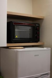 a microwave oven sitting on top of a refrigerator at Dimora Moscato Reale in Trani +27 photos