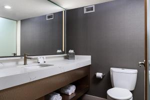 a bathroom with a sink and a toilet and a mirror at The STRAT Hotel, Casino & Tower in Las Vegas