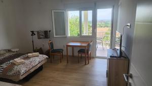 a bedroom with a bed and a table and a balcony at Udobna Soba Sa Prelepim Pogledom #4 in Mladenovac