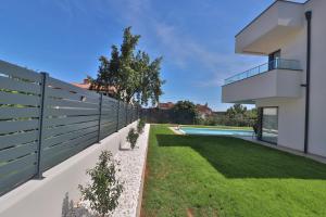 a backyard with a fence and a swimming pool at Villa Anna in Premantura