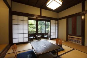 Cette chambre comprend une table, des chaises et des fenêtres. dans l'établissement Hazuki, à Ono