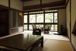 Hazuki في Ono: غرفة معيشة مع طاولة وكراسي ونافذة كبيرة