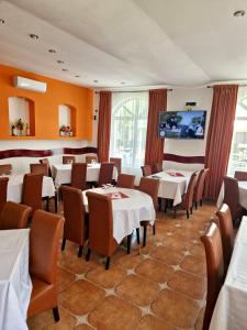 a restaurant with tables and chairs and a flat screen tv at Casa Coral Sulina in Sulina