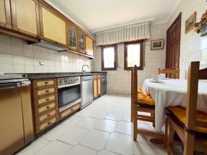 a kitchen with a table and a table and a kitchen with a tableablish at Casona de la Loma - 2806 in San Mamés de Meruelo